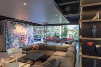 sala de estar con sofá y un mural colorido en Hotel Nodo - El hotel que respira, en Santiago