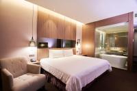 a bedroom with a bed and a chair and a tub at Hotel Intrendy in Taishan