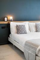 1 cama con almohadas blancas y pared azul en Attico43 B&amp;B, en Florencia
