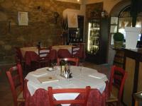 Un restaurante con mesas y sillas con copas de vino. en Hotel Le Badie, en Val di Perga