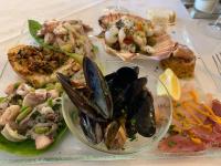 un plato de comida con marisco en una mesa en Hotel Le Badie, en Val di Perga