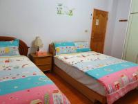a bedroom with two beds and a wooden floor at Yilan Xiang Feng Homestay in Wujie