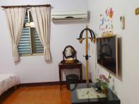 a room with a table and a window with a fan at Yilan Xiang Feng Homestay in Wujie
