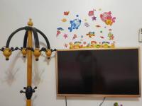 a television with a wall with butterflies and a lamp at Yilan Xiang Feng Homestay in Wujie