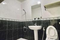 a bathroom with a sink and a toilet and a mirror at Seville Countrified B&amp;B in Hualien City