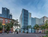 un edificio alto de cristal frente a algunos edificios en Maldron Hotel Belfast City, en Belfast