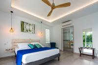 a bedroom with a bed and a ceiling fan at Hôtel La Christophine in Saint-François