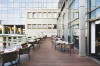 een restaurant met tafels en stoelen op een balkon bij Metropol Palace, Belgrade in Belgrado