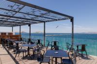 a row of tables and chairs on a deck with the water at Les Bords De Mer in Marseille