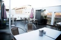 um pátio com mesas e cadeiras em uma varanda em Hotel Universal by Maxi Hoteles em Granada