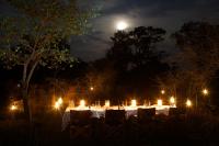 Una mesa larga con velas y luces por la noche. en Leopard Trails Yala, en Yala