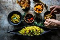 una mesa con una sartén de alimentos y tazones de comida en Leopard Trails Yala, en Yala