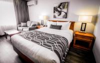 una habitación de hotel con una cama y una silla en Hôtel Le Voyageur, en Sept-Îles
