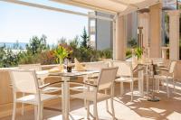eine Terrasse mit weißen Tischen und weißen Stühlen in der Unterkunft Hotel Villa MiraMar in Omiš