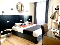 a bedroom with a bed with a black headboard and a mirror at Hôtel Jules in Le Touquet-Paris-Plage