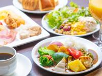 京都市にあるアパホテル〈京都駅堀川通〉の食べ物の皿とワインのグラスが置かれたテーブル