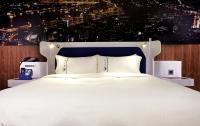 a white bed with a blue headboard and white pillows at Airline Inn Green Park Way in Taichung