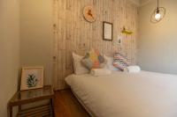 a bedroom with a bed and a clock on the wall at Cozy House Hostel in Hualien City