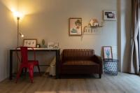 a living room with a chair and a desk at Cozy House Hostel in Hualien City