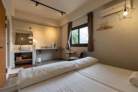 a bedroom with a bed and a desk and a window at Cozy House Hostel in Hualien City