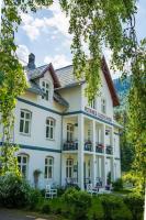 un gran edificio blanco con sillas delante en Petrines Gjestgiveri, en Norddal