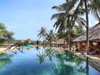 a swimming pool with palm trees and a resort at Novotel Lombok Resort & Villas in Kuta Lombok