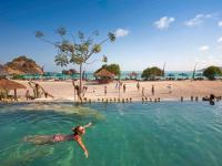 a person swimming in the water at a beach at Novotel Lombok Resort & Villas in Kuta Lombok