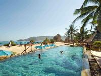 two people in a swimming pool next to a beach at Novotel Lombok Resort & Villas in Kuta Lombok