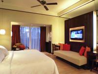 a hotel room with a bed and a couch at Novotel Lombok Resort & Villas in Kuta Lombok