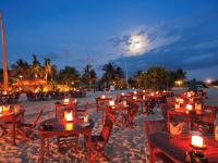 a group of tables and chairs on the beach at night at Novotel Lombok Resort & Villas in Kuta Lombok
