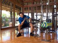 a man sitting on a bench in a gym at Novotel Lombok Resort & Villas in Kuta Lombok