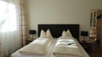 a bedroom with a bed with two white pillows at Hotel Garni Löwen in Silz
