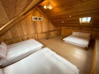 a room with two beds in a wooden cabin at Spring Ground Resort in Ren&#39;ai