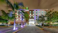 Un edificio con palmeras frente a una calle. en Holiday Inn Express Villahermosa by IHG, en Villahermosa