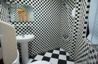 a bathroom with a black and white checkered floor at Galaxy Mini Inn in Taipei