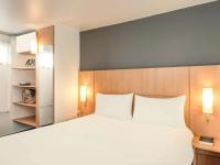 a bedroom with a large white bed with two pillows at ibis Paris Bastille Faubourg St Antoine in Paris