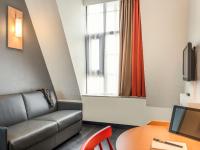 a living room with a couch and a table and a window at ibis Paris Bastille Faubourg St Antoine in Paris