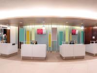 a lobby with colorful glass walls and white counters at Ibis Phuket Patong in Patong Beach