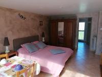 a bedroom with a large pink bed and a table at La Picholine in Sorède