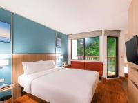 a bedroom with a white bed and a window at Ibis Phuket Patong in Patong Beach