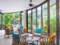 a lobby with chairs and tables and windows at Ibis Phuket Patong in Patong Beach