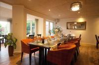 a dining room with a long table with orange chairs at Hotel - Restaurant Veldscholten in Lingen
