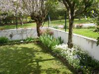 a garden with two trees and flowers at Chalet dans village in Saint-Maurice-en-Trièves