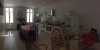 a kitchen and living room with a table and chairs at Logis de Villemaurine in Saint-Émilion