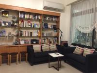 a living room with a couch and a book shelf at Amicasa Guesthouse in Hualien City