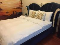 a bed with a black and white headboard and pillows at Amicasa Guesthouse in Hualien City