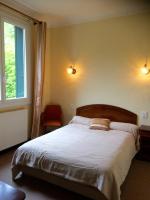 ein Schlafzimmer mit einem Bett mit zwei Kissen und einem Fenster in der Unterkunft Hôtel Le Val Du Tech in Prats-de-Mollo-la-Preste