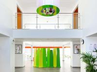 a hallway with bright green and orange columns in a building at ibis Styles Nivelles in Nivelles