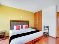 Un dormitorio con una cama grande con almohadas rojas. en Hotel Patzcuaro, en Pátzcuaro
