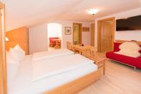 a bedroom with a bed and a red couch at Das kleine, feine SONNWEND in Alpbach